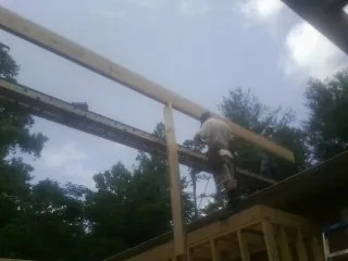 Carpenter setting a ridge beam over a new addition frame — Ice Dam Removal by Roofing Brothers in Chino