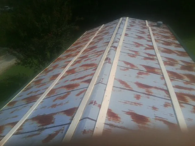 Rusted metal roof panels with new wood purlins before replacement — Storm Damage Roof Repair in Chino by Roofing Brothers
