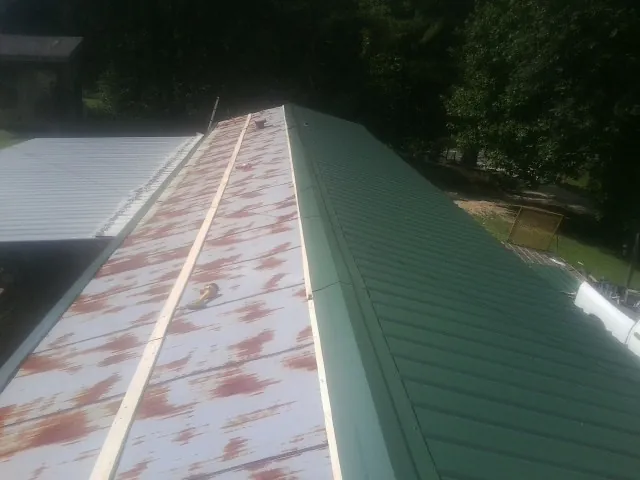 Old rusted panels beside newly installed green metal roofing — Wind Damage Roof Repair by Roofing Brothers in Chino