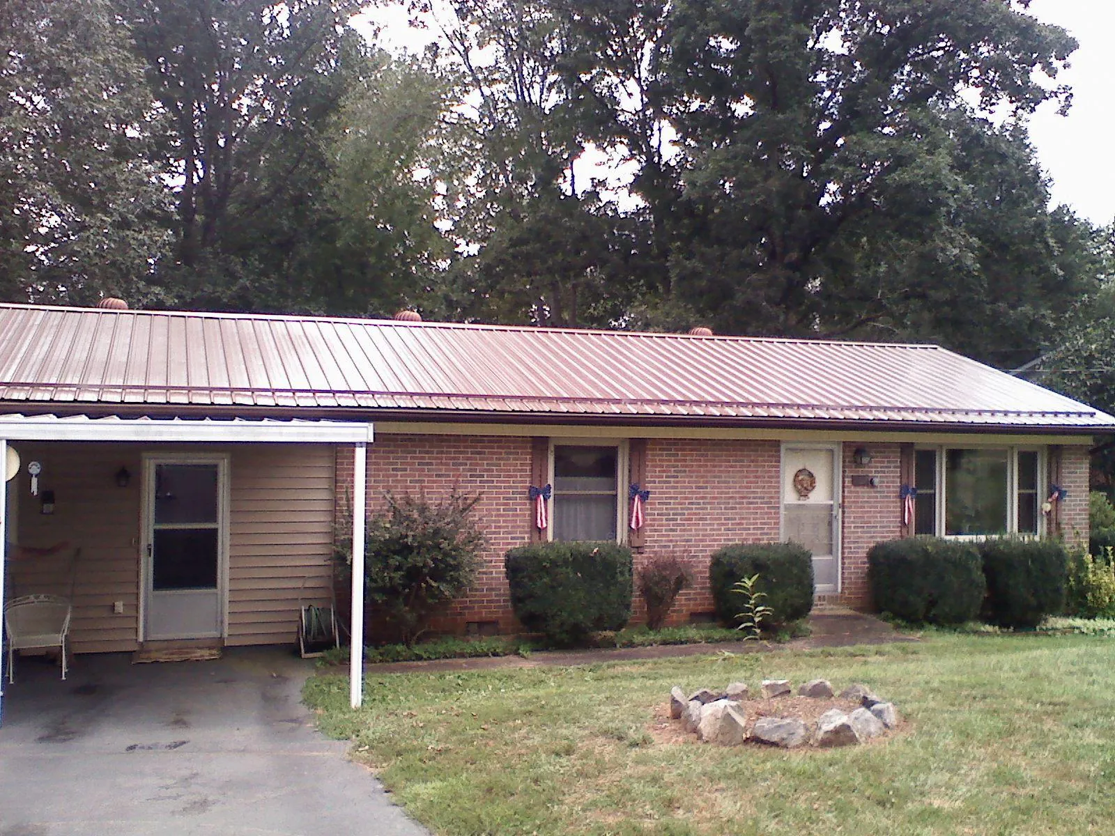 Bronze metal roof and carport on a brick ranch home — Roof Repair work by our crew in Chino